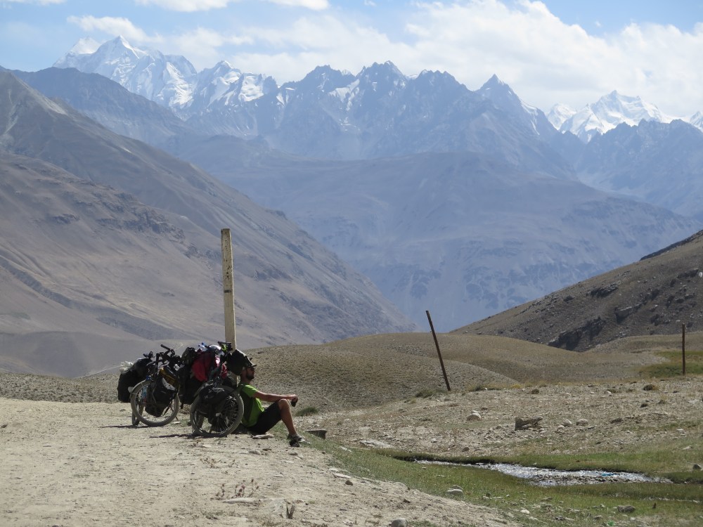 A little exhausted after pushing my bike through miles of sand, while the sight of the Hindu Kush in the background makes everything OK. Photo courtesy of Hubert.